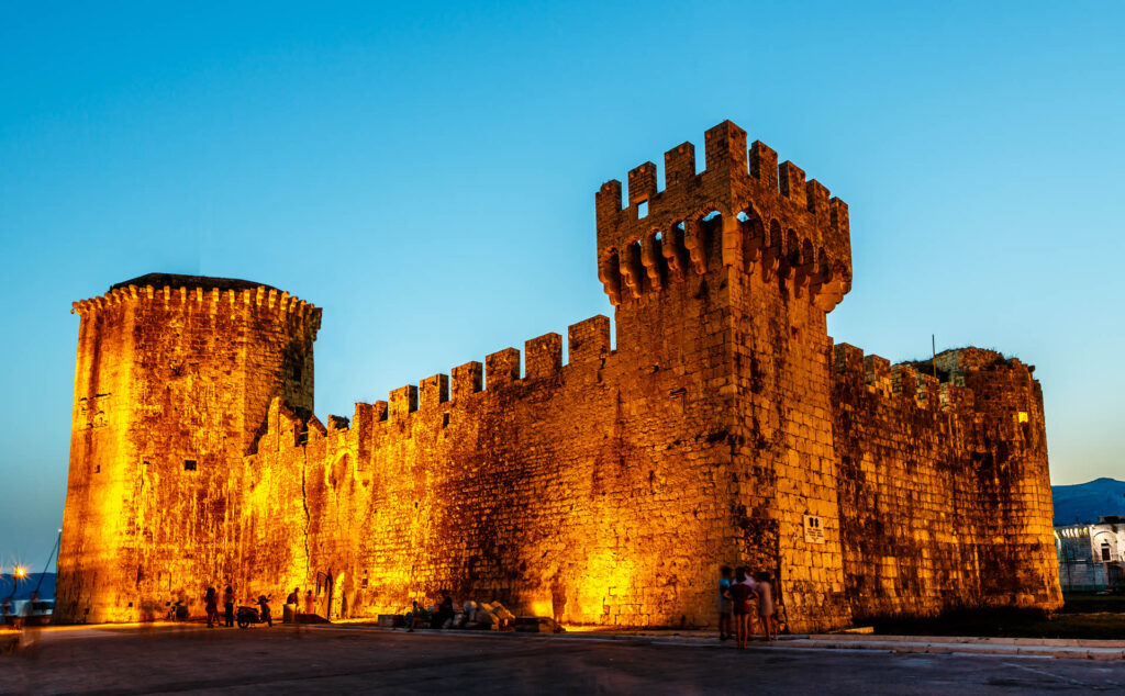 Capture the essence of Trogir's medieval legacy with an image of the Kamerlengo Fortress, where ancient stone walls whisper tales of history against the backdrop of the Adriatic Sea.