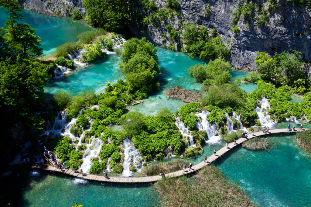 Aerial view of Plitvice National Park: Crystal-clear lakes, cascading waterfalls, and lush greenery create a stunning natural landscape.
