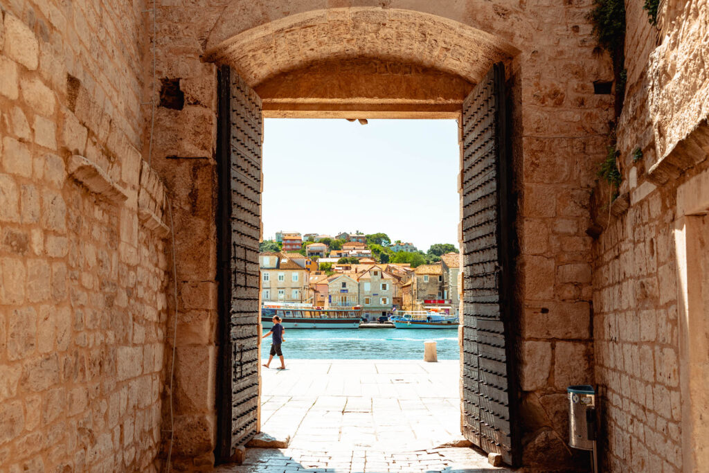 Trogir's South Town Gate in Croatia -  this historic stone gateway, known as Porta Sponza, served as a crucial maritime entry point to the medieval town. Architectural details include arches and Venetian influences, reflecting the town's strategic importance and maritime heritage.
